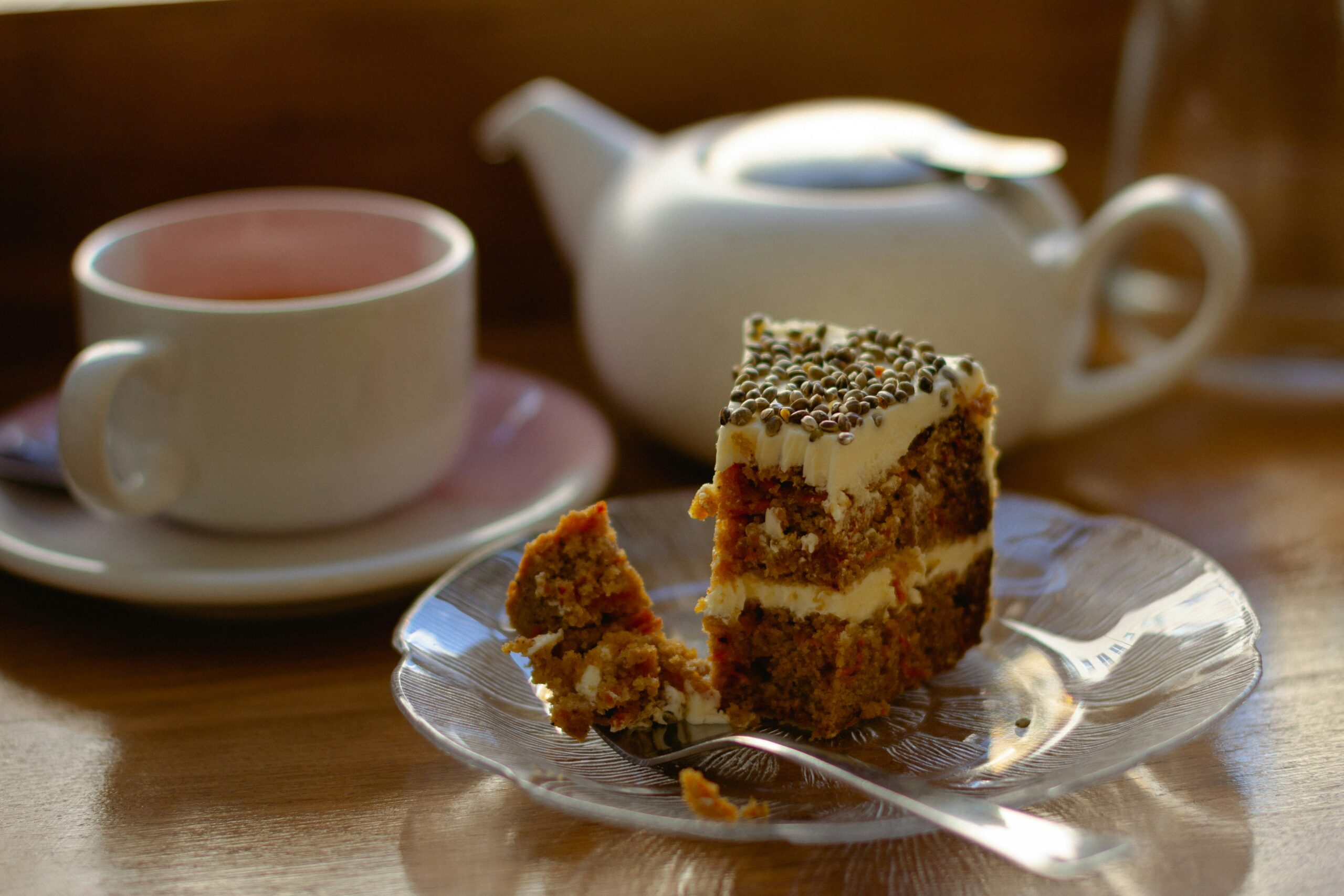 An image of a cake, tea cup and tea pot