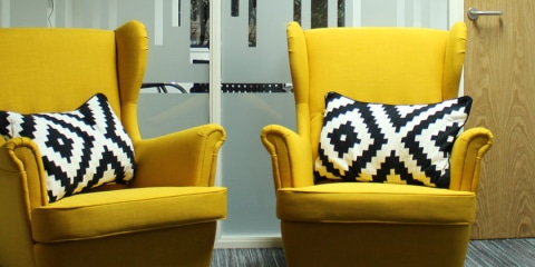 Bright yellow sofa chairs placed in a reception room.