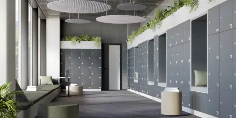 Large room filled with grey lockers with planters on top, and acoustic panels hanging from the ceiling.