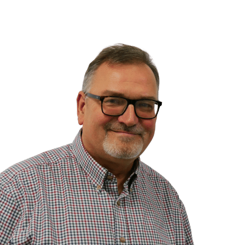 A male colleague smiling in front of a white wall.