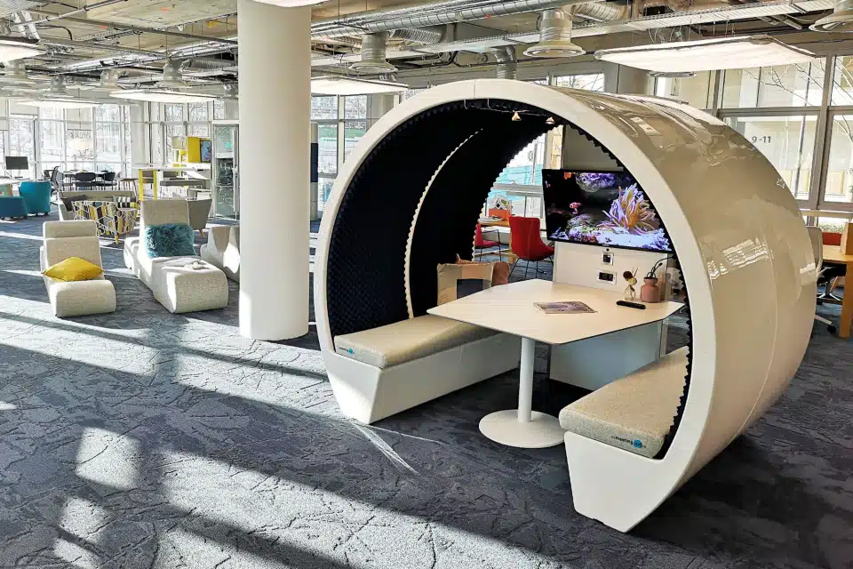 A white acoustic meeting pod, open on two sides.