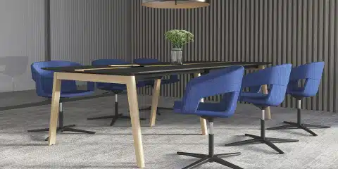 Boardroom with a table and dark blue chairs and a vase.