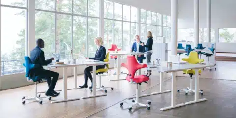 A large spacious room with several brightly coloured ergonomic chairs.