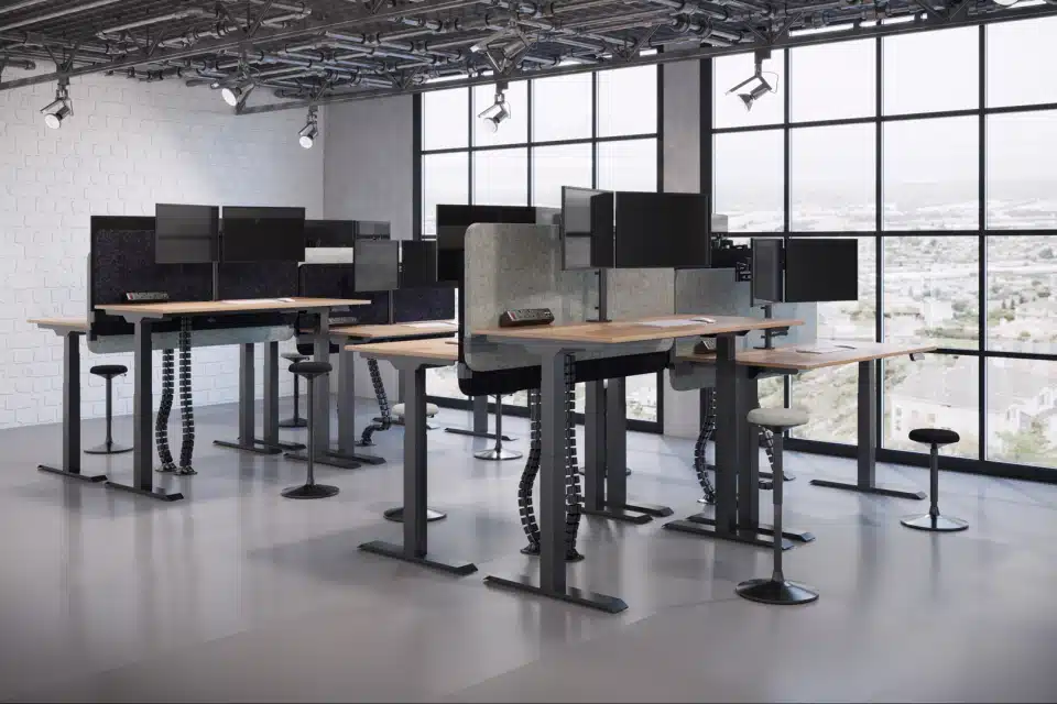 An industrial room with standing office desks and monitors.