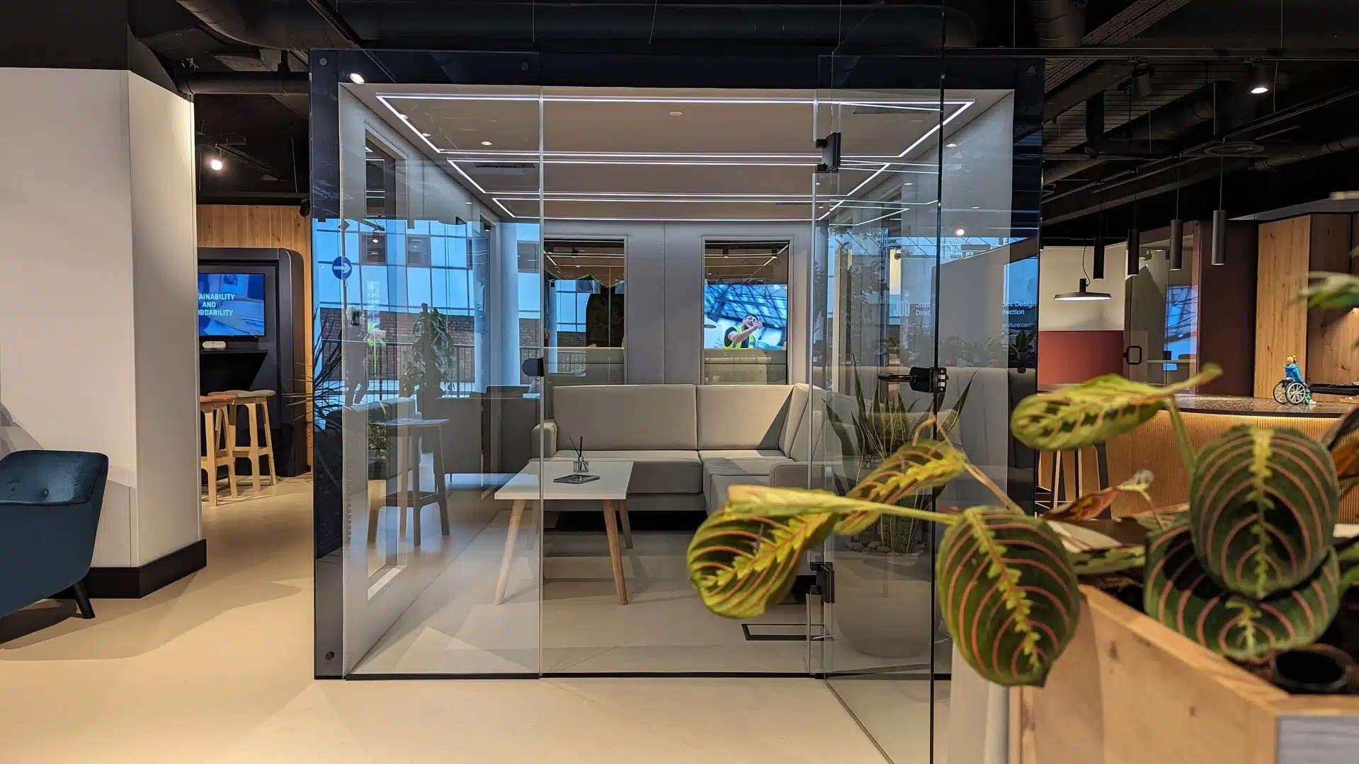 A large glass pod with green plants.