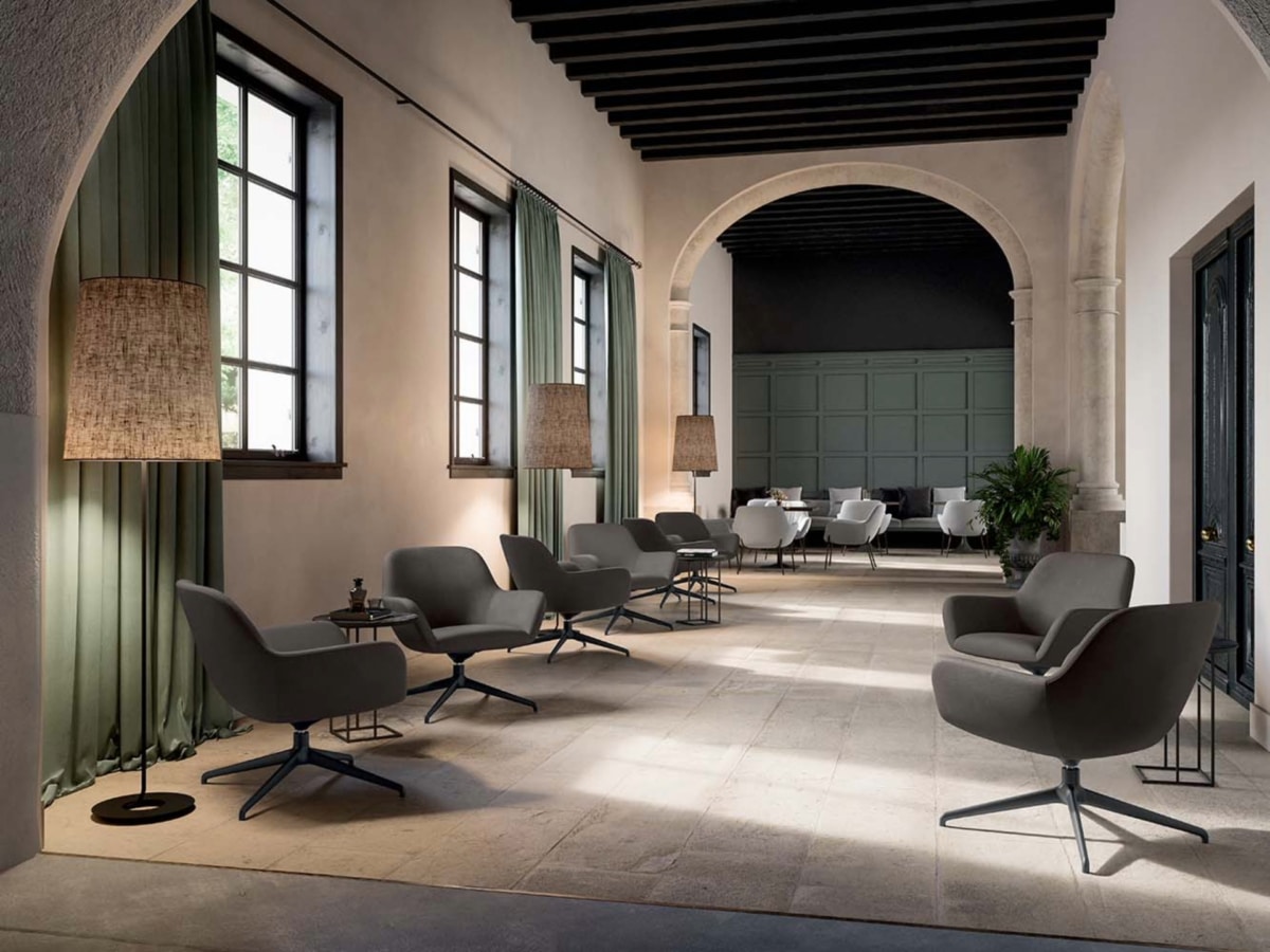 A curated arrangement of City Déco lounge chairs by Quadrifoglio in a spacious, modern hotel lobby with floor-to-ceiling windows.