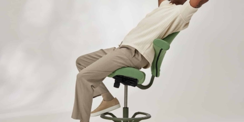 A man sitting on a green ergonomic chair,