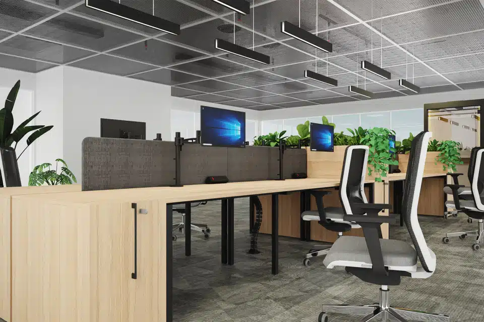 Office room with several bench desks placed together with acoustic screens dividers and monitors placed on top.