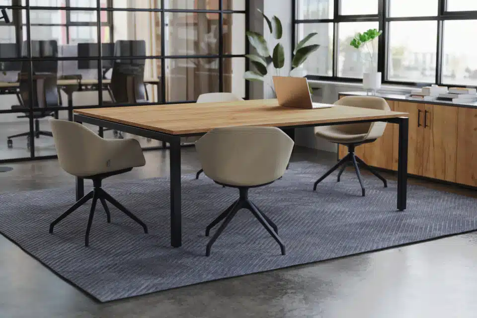 Modern Boardroom with Long Table, Window, and Plant.