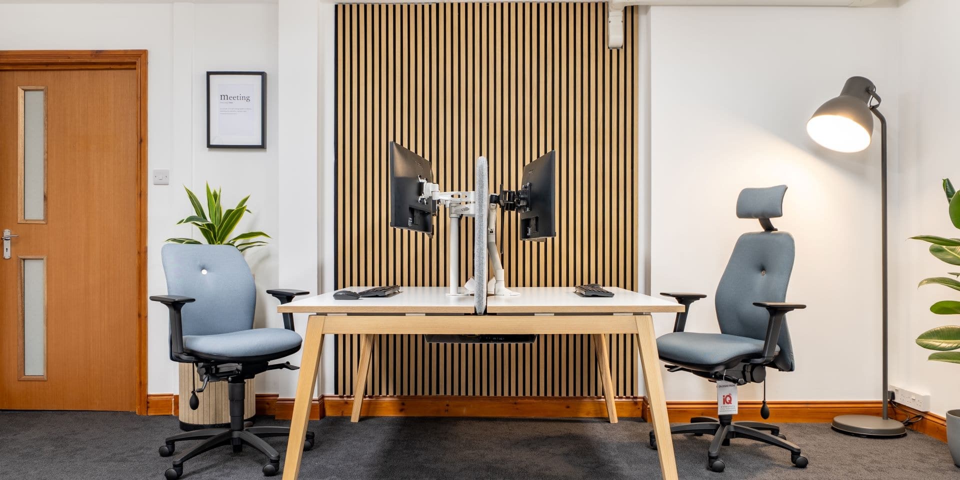 Office room with two ergonomic chairs and bench desk.
