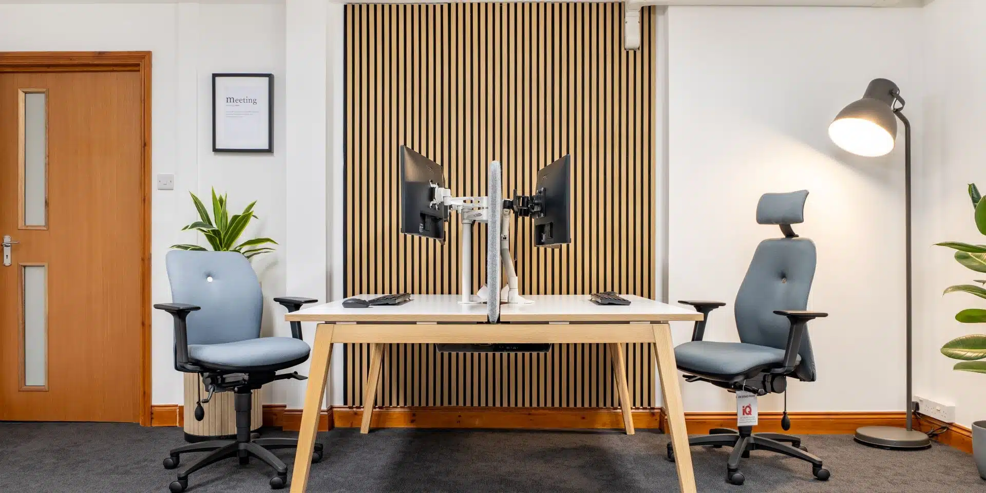 Office room with two ergonomic chairs and bench desk.