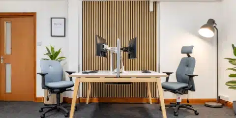 Office room with two ergonomic chairs and bench desk.