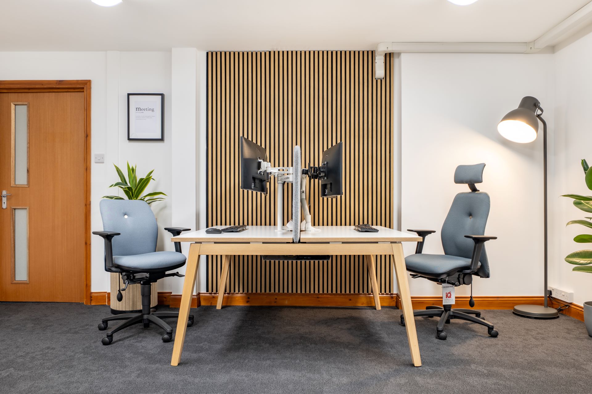Office room with two ergonomic chairs and bench desk.