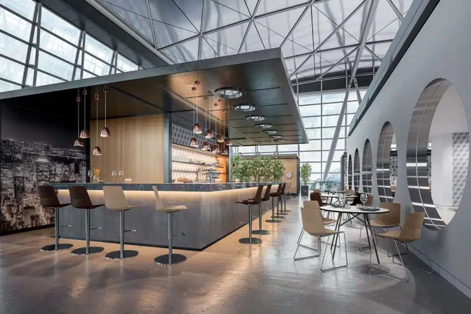 A spacious, modern collaborative workspace in the UK showcases an installation of QG Clue Meeting Chairs. The chairs are arranged around large tables, creating an active and engaging environment for teamwork and discussions. The overall aesthetic is contemporary and inviting, designed to promote creativity and productivity.