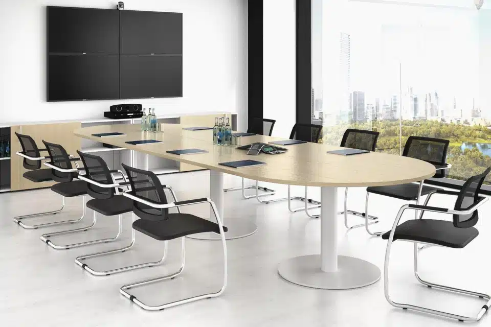 A room with a large table and meeting chairs.