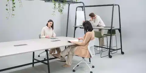 A room with a standard and high table with a green planter above.