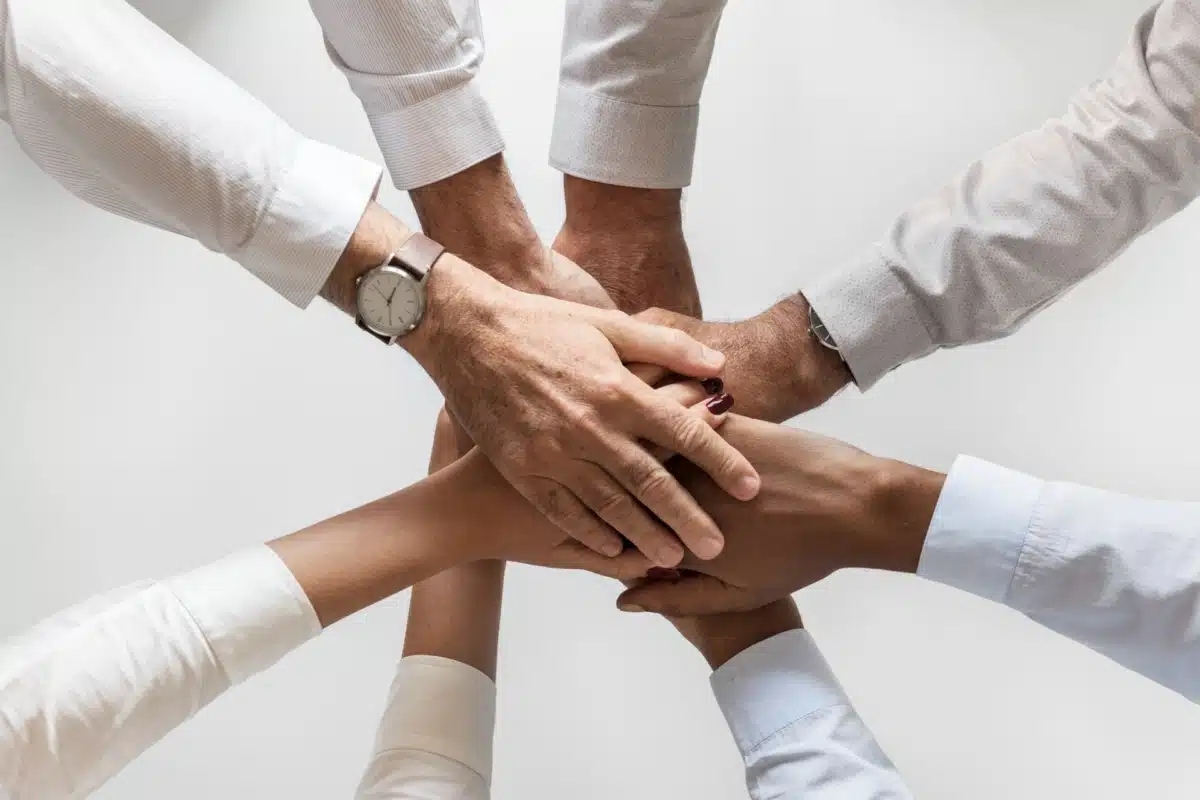 A group of office people shaking heads as a seal of a deal.