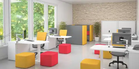 White desk in an office with yellow and red soft seating