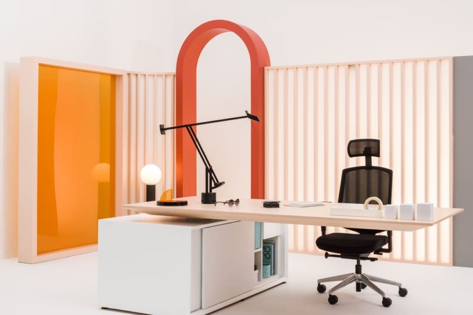A modern MDD Gravity executive desk positioned in a stylish office space against a striking orange accent wall.