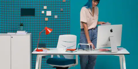 Office room with a blue background with a white office desk.