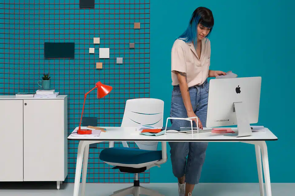 Office room with a blue background with a white office desk.