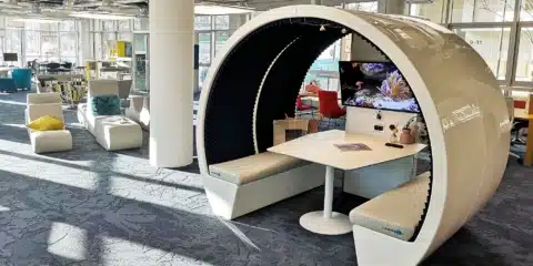 A large room with three white pods.