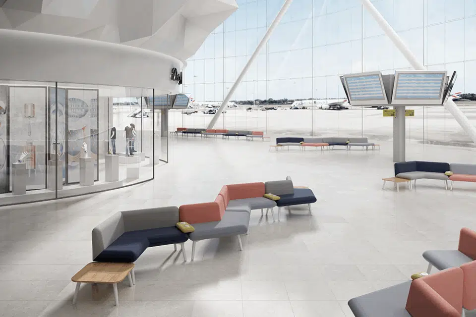 Several modular sofas inside a large open style airport waiting room.