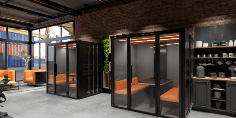 A large industrial room with two large acoustic pods.