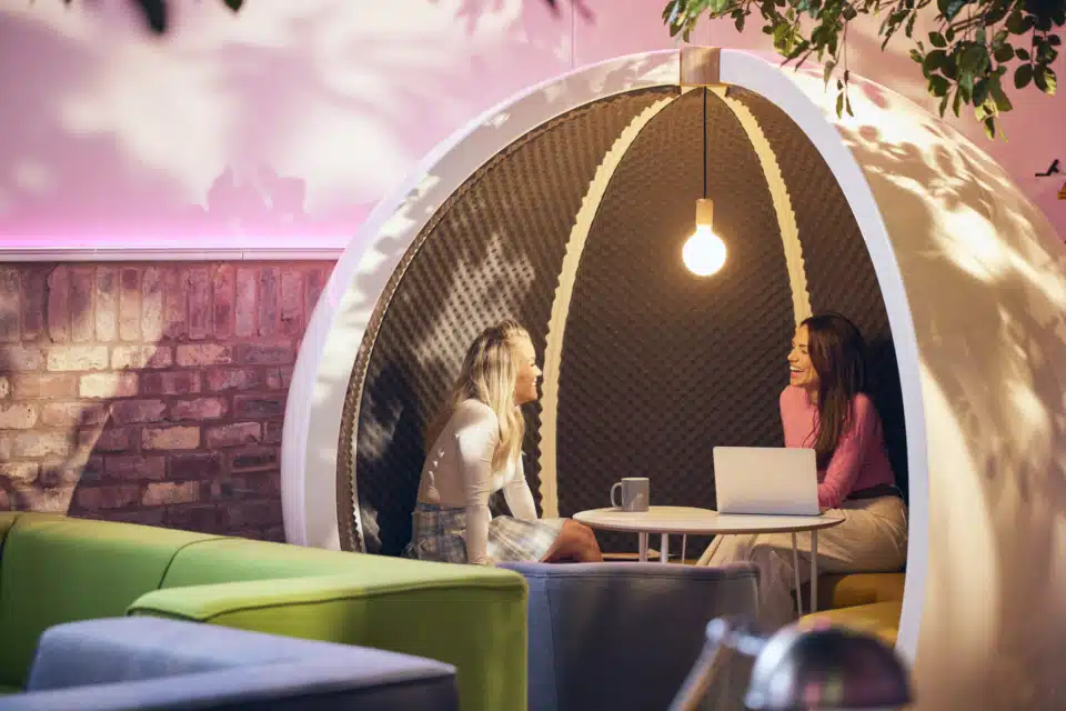 A globe open escape white pod in a casual room.
