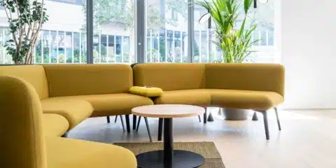 A large mustard colour modular sofa placed in the large light room.