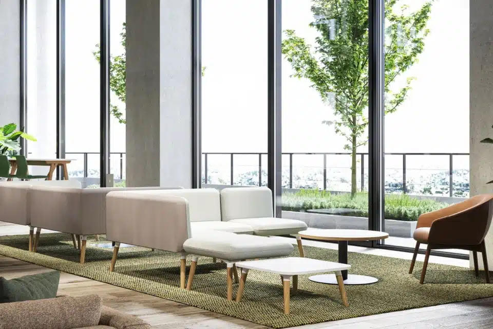 A white modular sofa that is in a large spacious and light room.