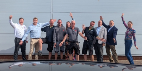 A happy, silly group of people from two different companies posing together.