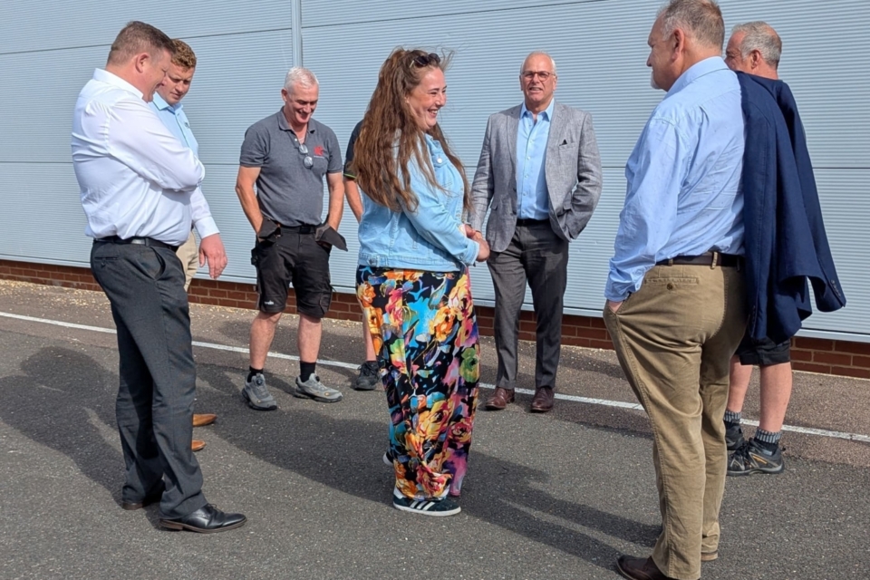 A group of colleagues from Tick Solutions is engaging in a cheerful conversation.