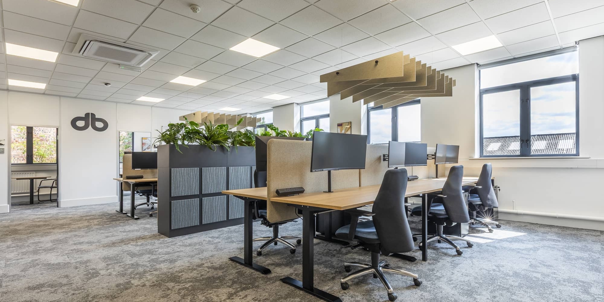 Several Alto 1 high standing desks placed in a room with ergonomic chairs.