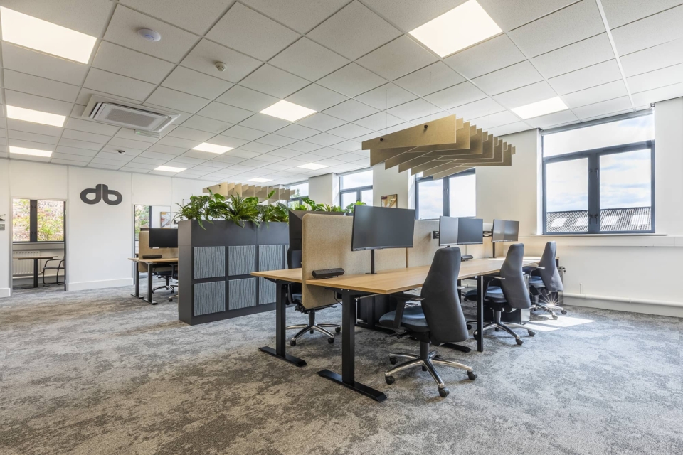 Several Alto 1 high standing desks placed in a room with ergonomic chairs.