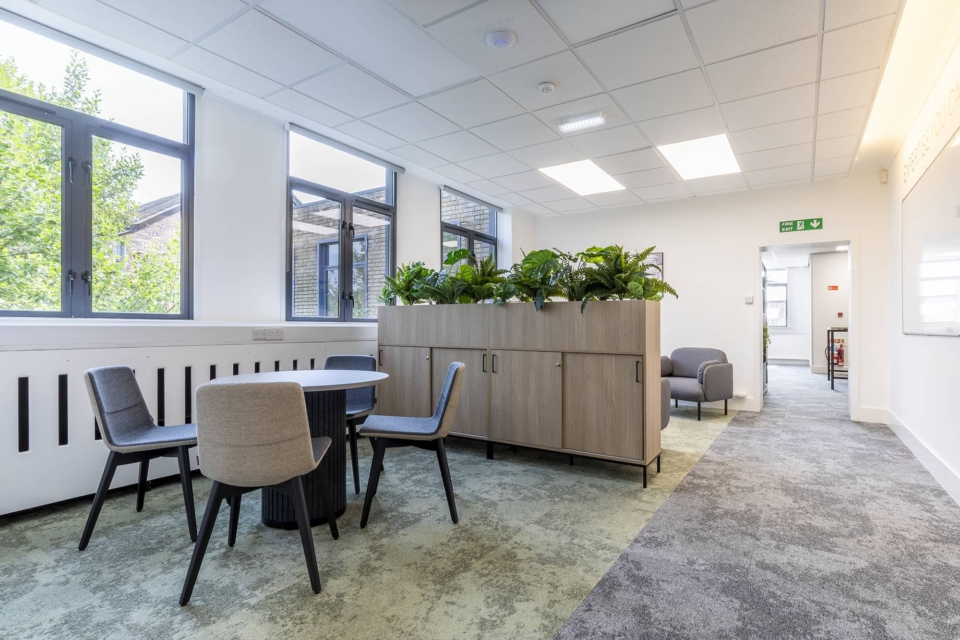A room with lockers and planters dividing the space.