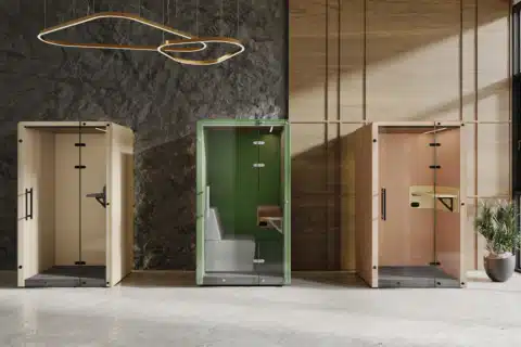 Three colored booths, one yellow, one green, and one orange, are arranged in a row in a lifestyle image.