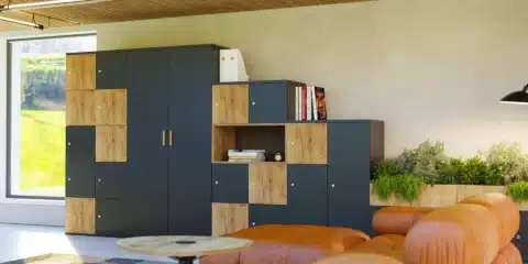 A modern room filled with numerous large, grey modular storage lockers arranged in rows.