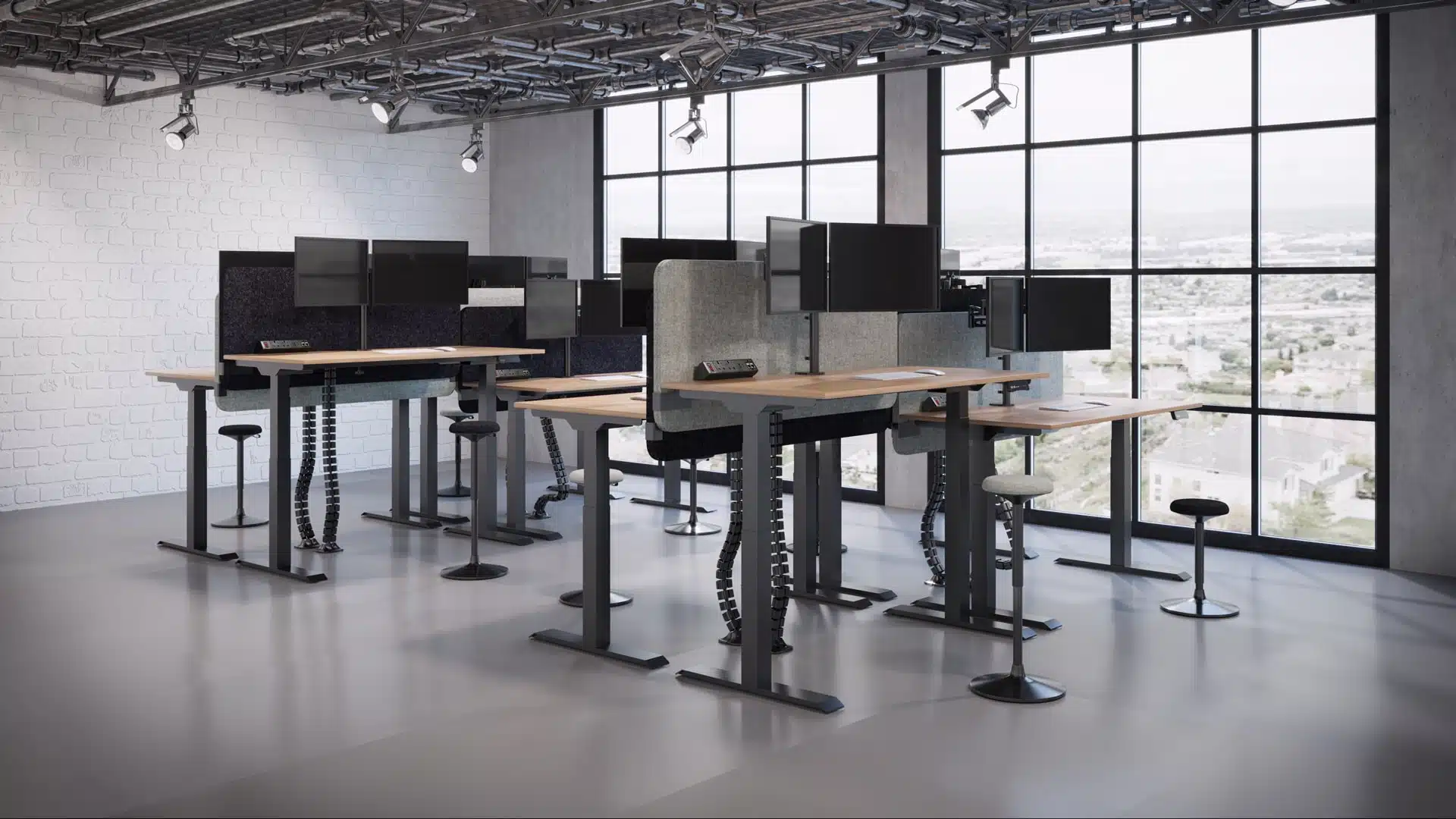 Industrial office with adjustable desks, monitors, and screens.
