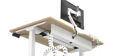 White adjustable standing desk with wood top and cable spine.