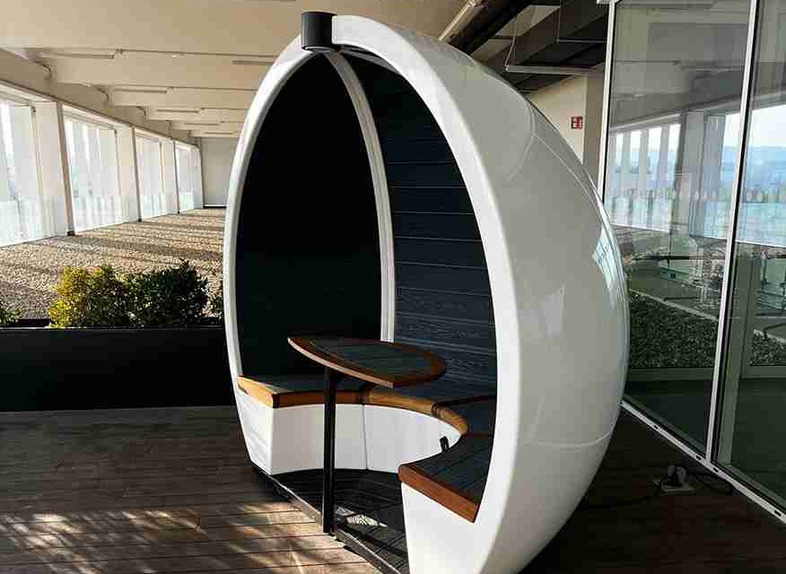 White Outdoor Orb pods are situated outside a modern office building.