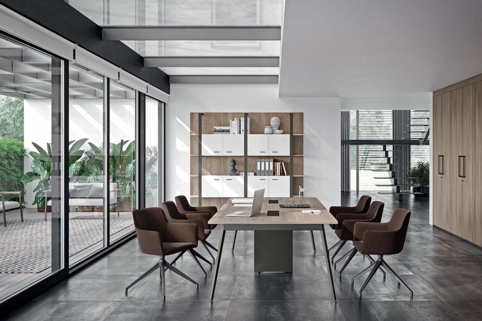 Collaborative X3 desks in a bright room with screens and divider panels.