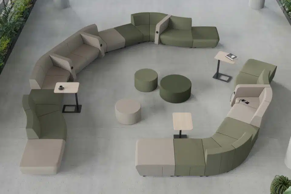 Top-down view of a modern office lounge featuring a semi-circular green and beige modular sofa.