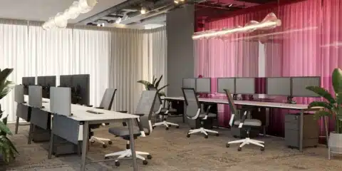 A modern open-plan office with rows of grey and white Elite Loop mesh task chairs, paired with white desks and dual-monitor setups.