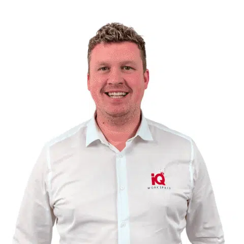 A white male standing in front a white wall.