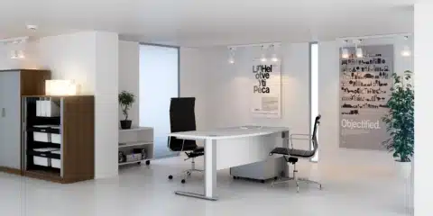 A modern, minimalist office featuring a white curved desk, two black leather executive chairs, and wooden storage cabinets against a clean white interior.