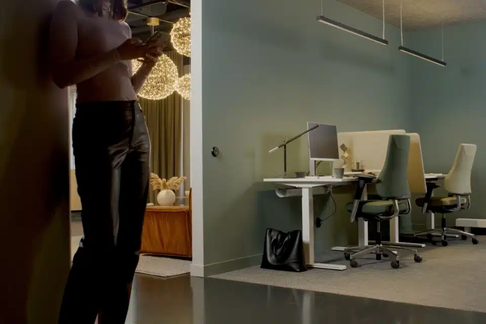 RH Axia ergonomic office chairs in a modern workspace with green walls and sit-stand desks.