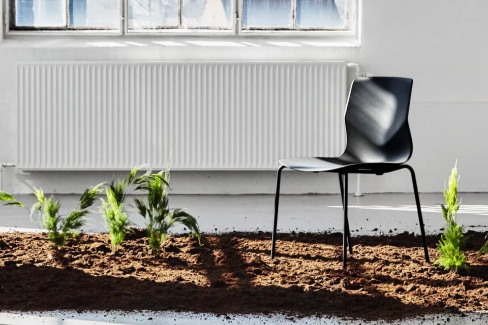Black FourSure 44 stackable breakout chair with EU Ecolabel certification in a bright, eco-friendly office setting.