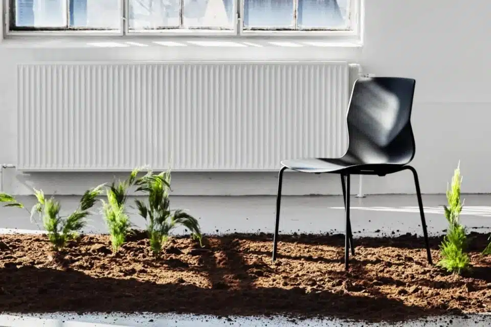 Black FourSure 44 stackable breakout chair with EU Ecolabel certification in a bright, eco-friendly office setting.