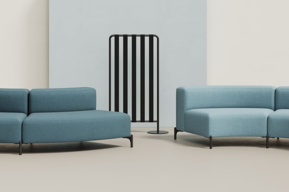 Blue FourPeople modular sofa units with a black metal frame privacy screen.